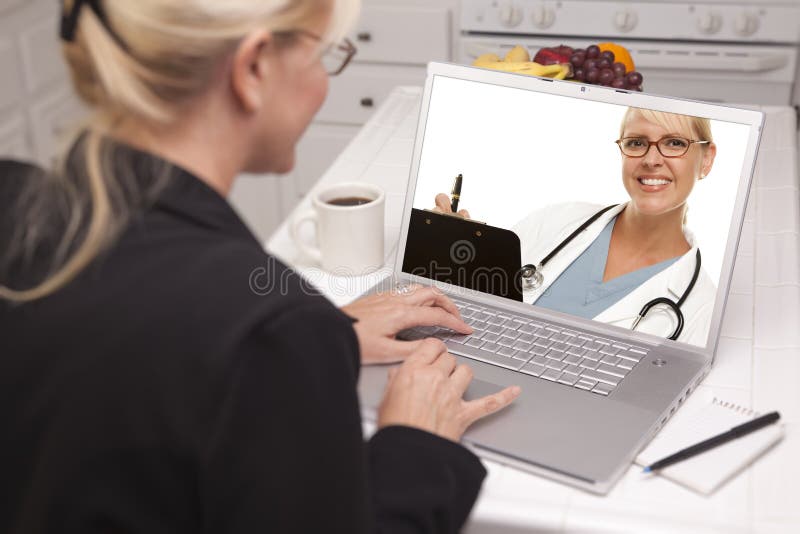 Woman In Kitchen Using Laptop - Online with Nurse or Doctor