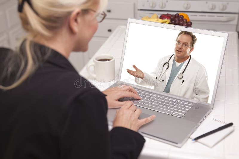 Woman In Kitchen Using Laptop - Online with Nurse or Doctor