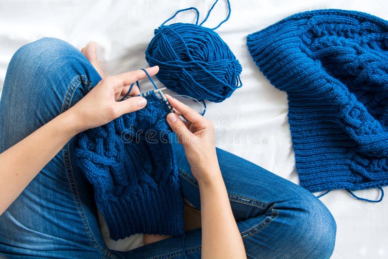 Woman knitting blue sweater