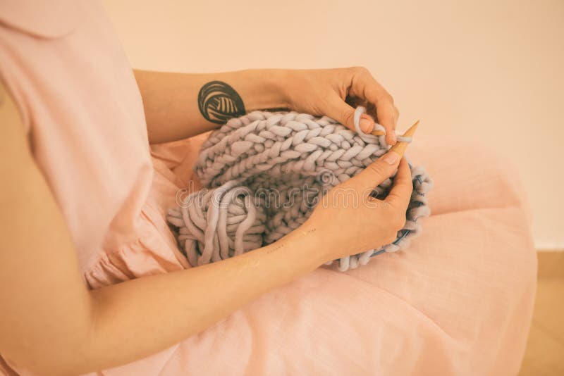 Woman is knitting on knitting knitting. Pink delicate shades. stock photos Woman is knitting on knitting knitting. Pink delicate shades. stock photos