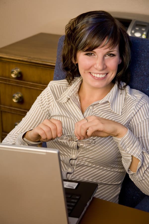 A young business woman sitting in front of her laptop. A young business woman sitting in front of her laptop