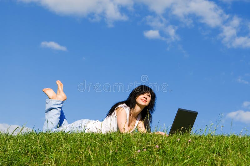 Woman with laptop on the green grass