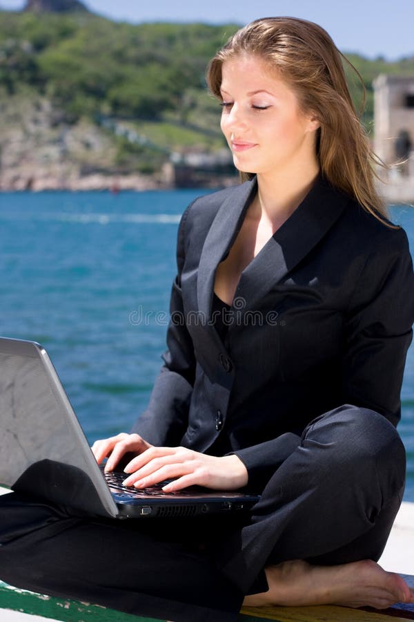 Woman with laptop near the sea