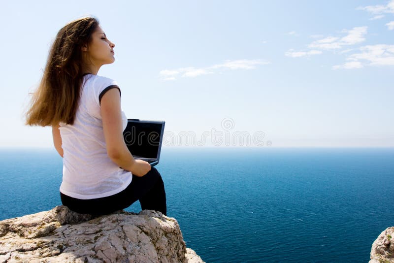 Woman with laptop and sea