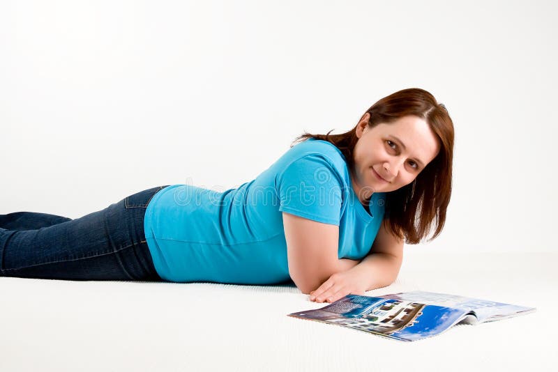 Woman laying down and reading magazine