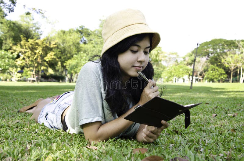 Woman laying on grass and thinking in park