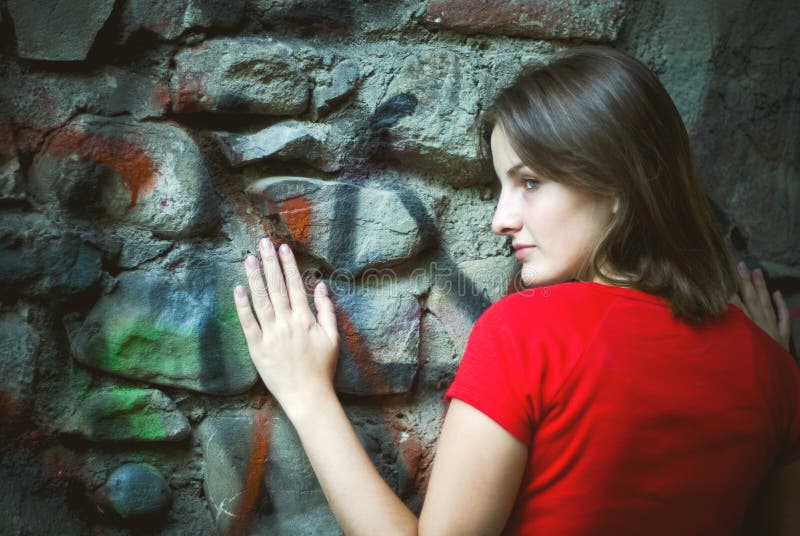 Woman leaning on graffiti wall