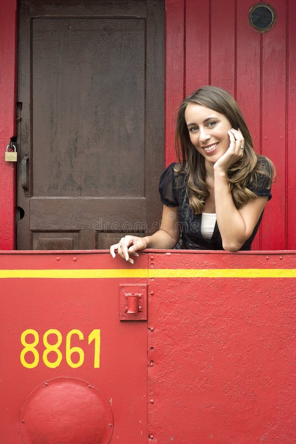 Woman Leaning On Railing In Red Train Caboose Car. Portrait of beautiful young woman leaning on railing in red train caboose car stock images Woman Leaning On Railing In Red Train Caboose Car. Portrait of beautiful young woman leaning on railing in red train caboose car stock images