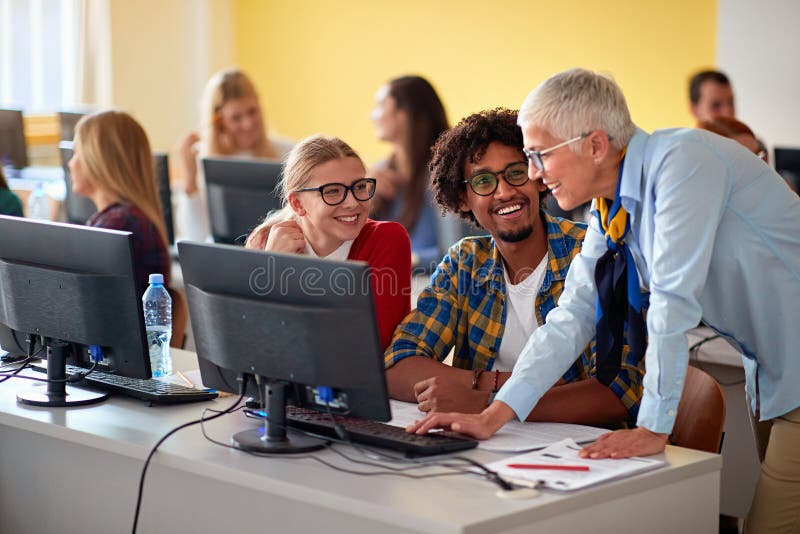 Woman Lecturer in Computer Class Assisting Group of Student Stock Image