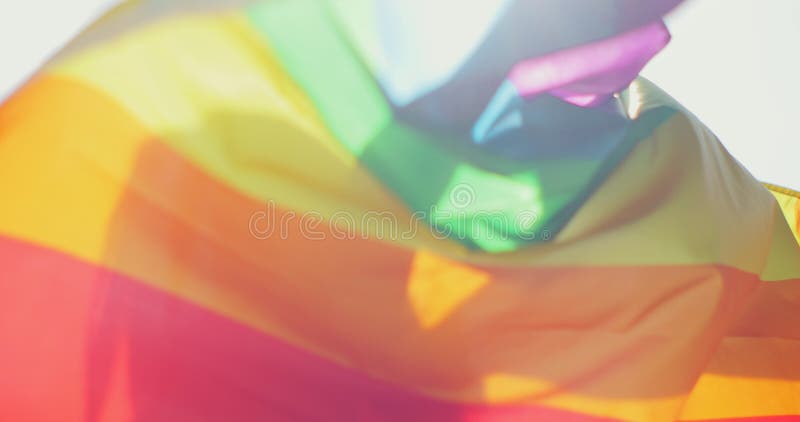 Woman lesbian holds a LGBT gender identity flag on a background. Smiled young woman spinning around with lgbt flag on royalty free stock photography