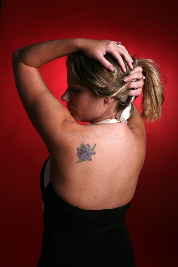 Woman lifting her hair and showing her tattoo