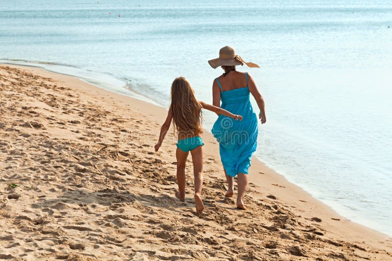 Woman and little girl on a morning walk by the sea stock images Woman and little girl on a morning walk by the sea stock images
