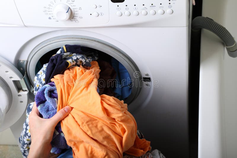 Woman loading the washing machine in bathroom stock photography