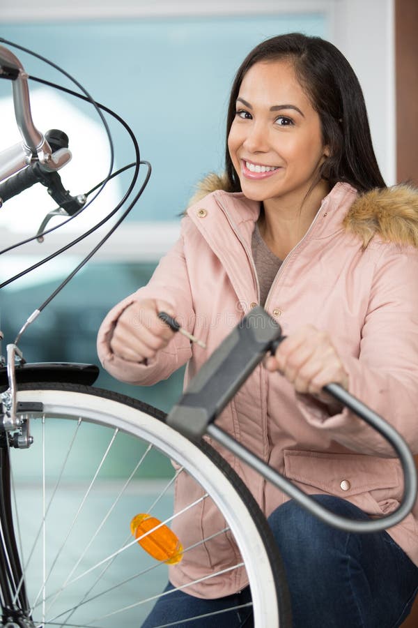 Woman locking bicycle stock photo. Image of bike, lock 214070998