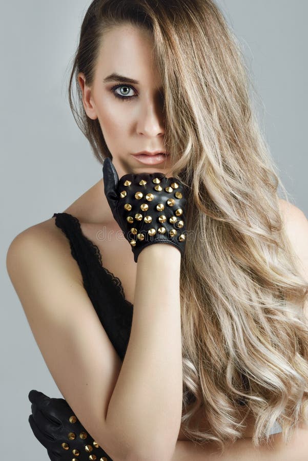 Woman with long hair and blue eyes wearing black lingerie and gloves