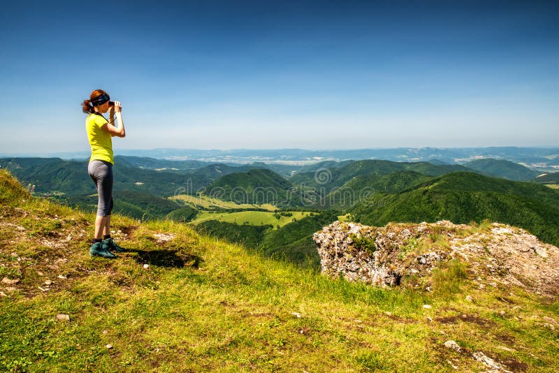 Žena pri pohľade cez ďalekohľad na krásnu horskú krajinu. Vrch Strážov, Slovensko