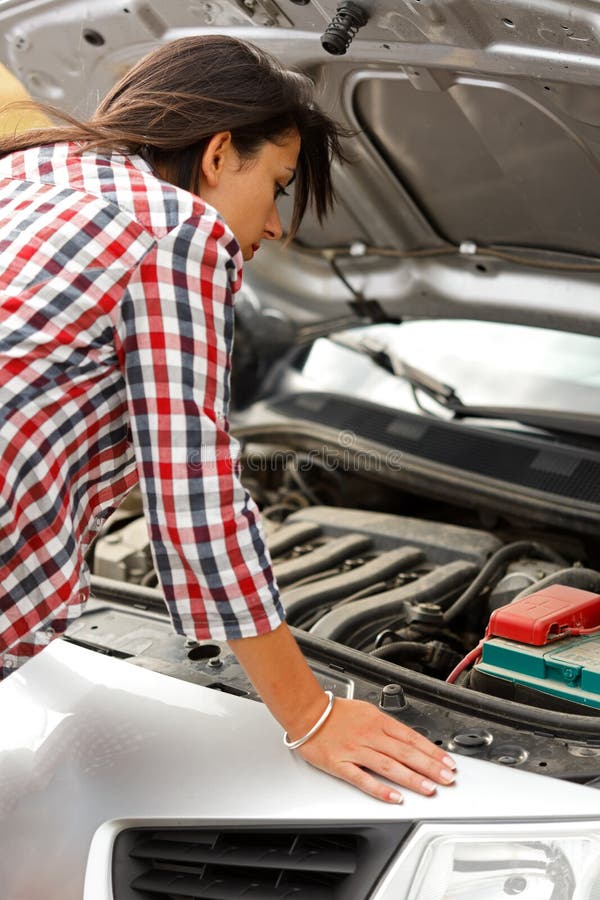 Woman looking at the broken cars engine stock images Woman looking at the broken cars engine stock images