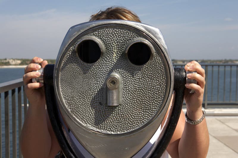 Woman looking through a coin operated binoculars