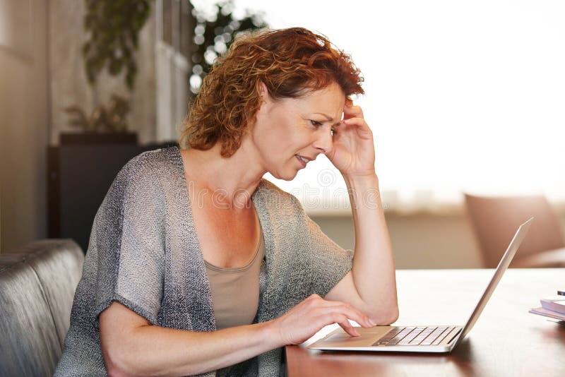 Woman looking at computer thinking sitting at table royalty free stock photo