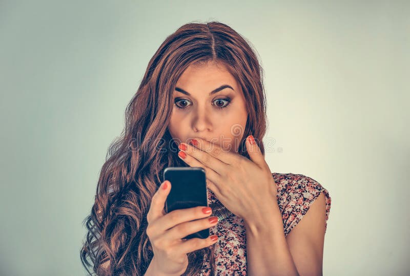 Woman looking at her phone with shocked