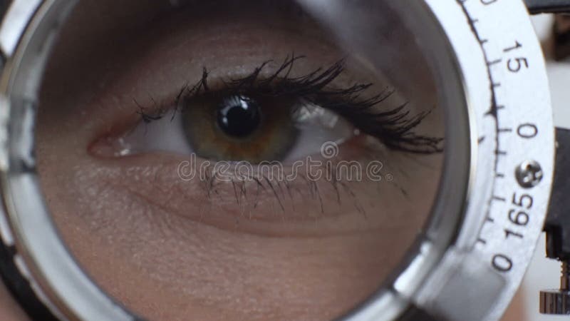 Woman looking through phoropter choosing proper lens, ophthalmologic clinic