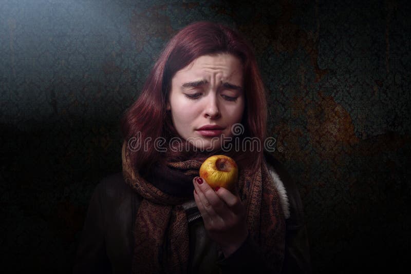 Woman looking on a rotten apple