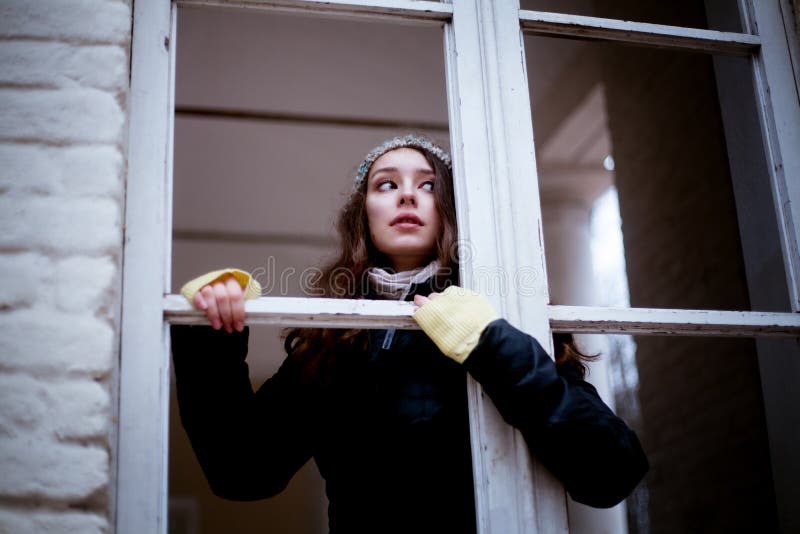 Woman looking through the window and fearing of something