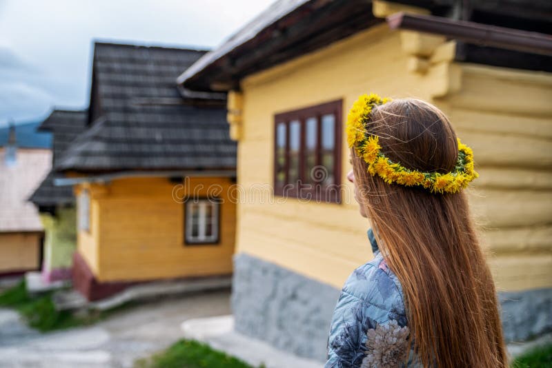 Žena při pohledu na dřevěnou chatu v obci Vlkolínec na Slovensku