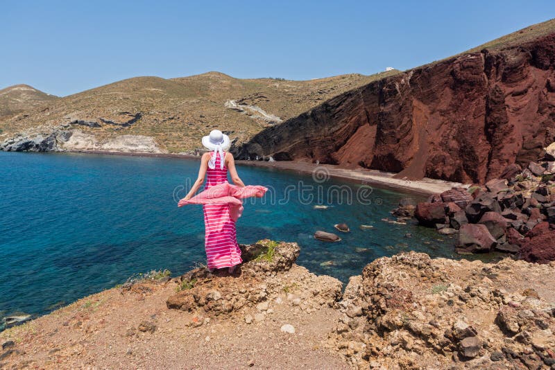 Woman looks at the red beach in Santorini, Greece