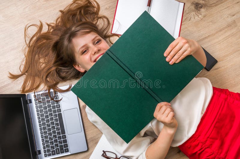 Woman lying on back and covering her face with book stock photos Woman lying on back and covering her face with book stock photos