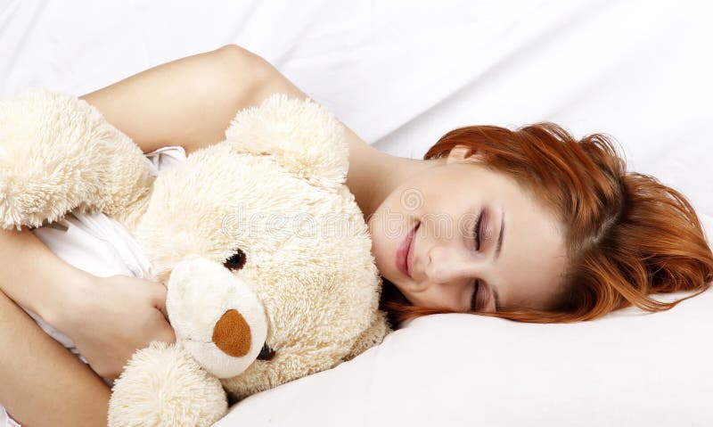 Woman lying in the bed with soft toy.