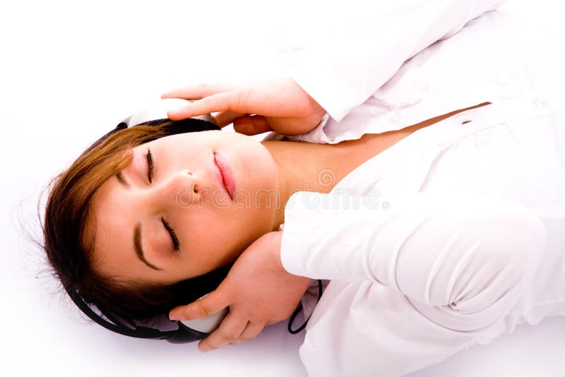 Woman lying down on floor tuned to music stock image