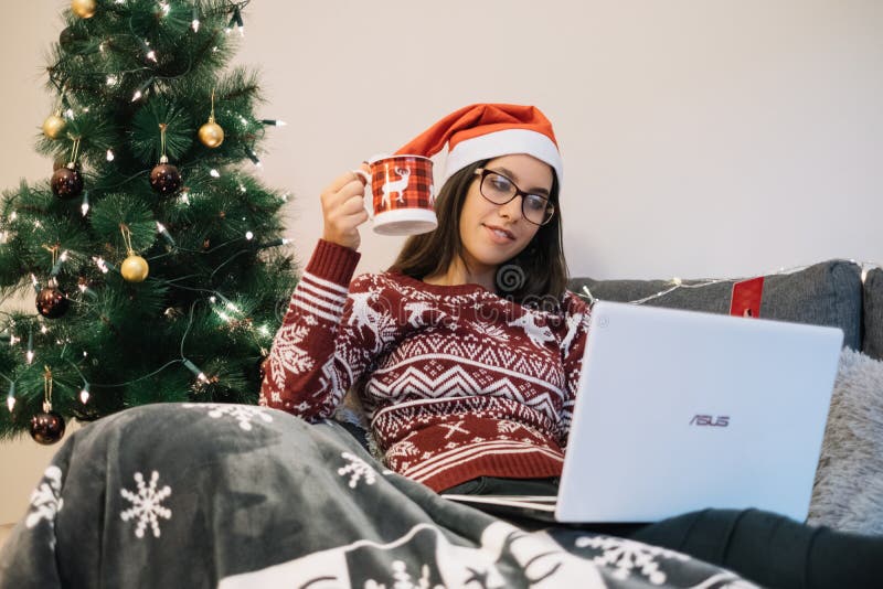 Woman lying on sofa while buying gifts online