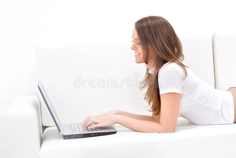 Woman lying on sofa with laptop.