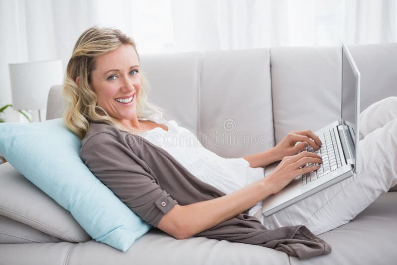 Woman Lying on Sofa Using Her Laptop Smiling at Camera Stock Image ...