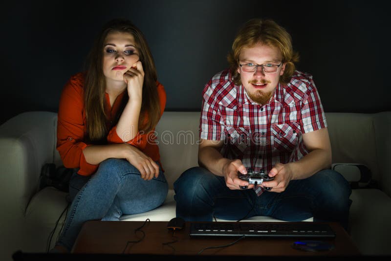 Man Playing Video Games At Home And His Girlfriend Bored Beside Looking At  Him Stock Photo, Picture and Royalty Free Image. Image 52407663.