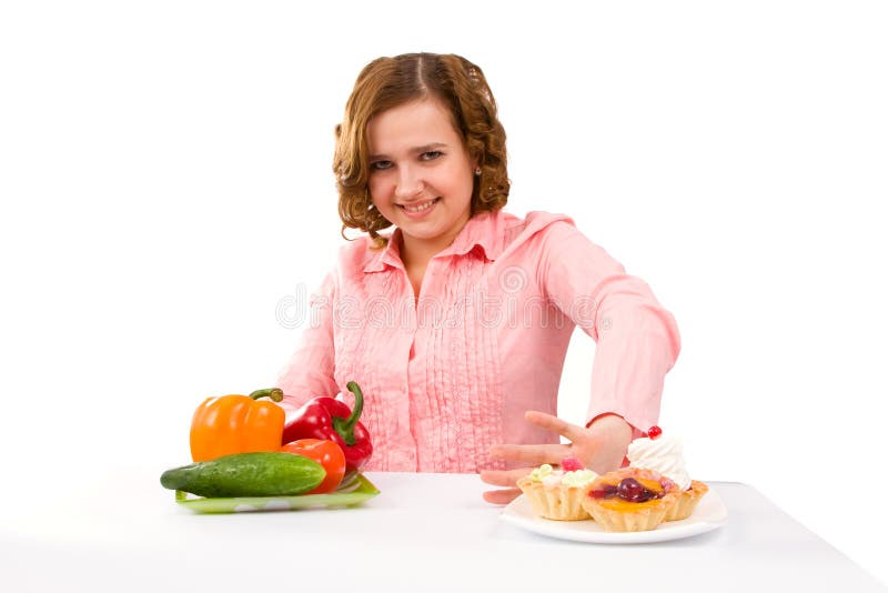 Woman makes choice of cakes and vegetables