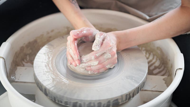 Woman making ceramic pottery on wheel, creation of ceramic ware. Concept for small business or hobby.