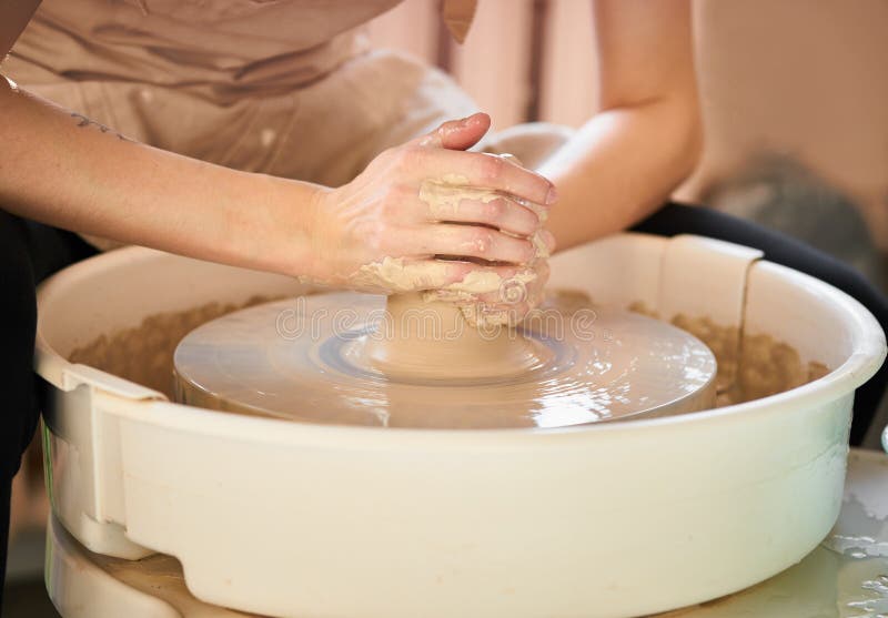 Woman making ceramic pottery on wheel, creation of ceramic ware. Concept of women`s work, craft.