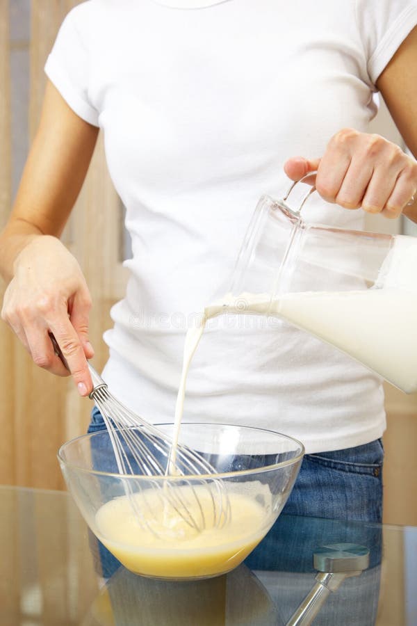 Woman making egg-and-milk shake in the kitchen