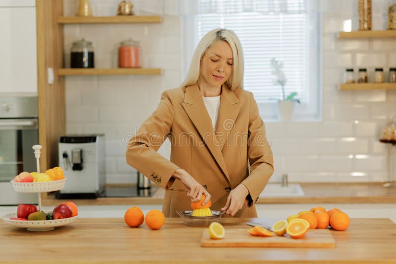 Woman making fresh orange juice royalty free stock photography