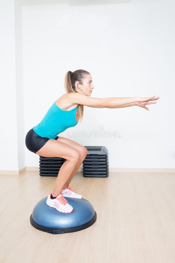 Woman making squats on balance trainer royalty free stock images Woman making squats on balance trainer royalty free stock images