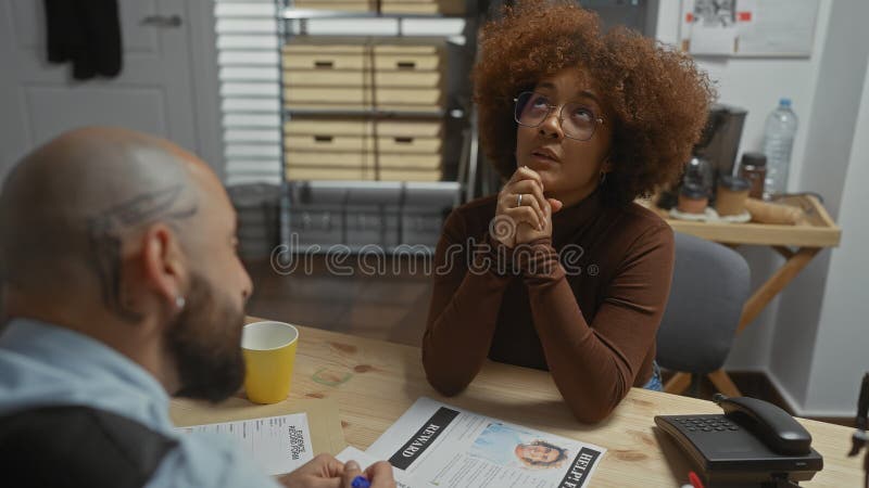 A woman and a man examine documents in an office setting, suggesting a detective work scenario stock photos