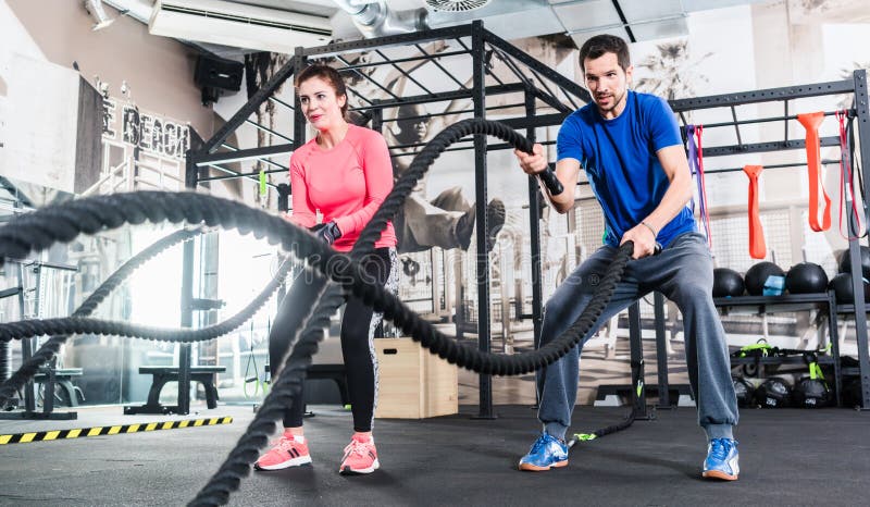 Gym People Training Battle Rope Exercise Panorama. Fitness Gym Fit Couple  Exercising With Battling Ropes Stock Photo - Image Of Ropes, Muscular:  227087954