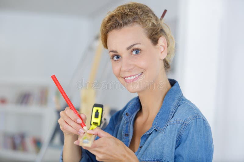 Woman measuring wood at home royalty free stock photos Woman measuring wood at home royalty free stock photos