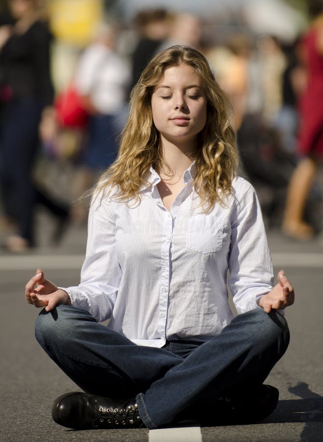 Woman meditating in busy urban street