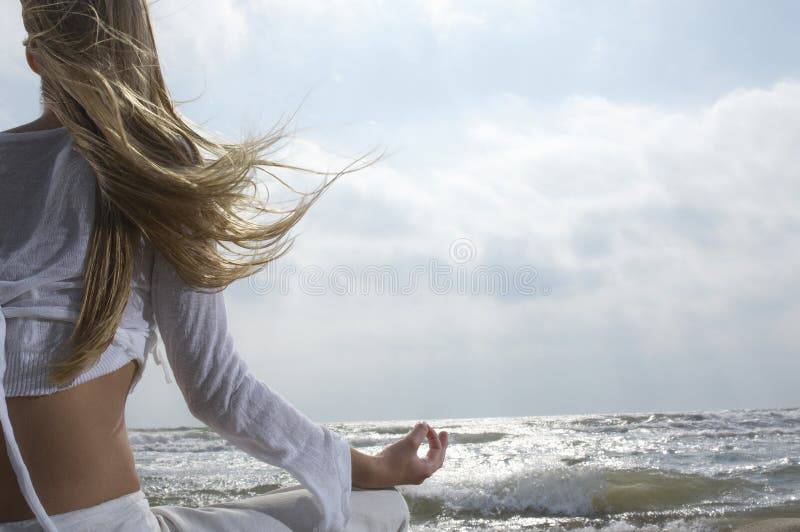 Woman Meditating By The Ocean