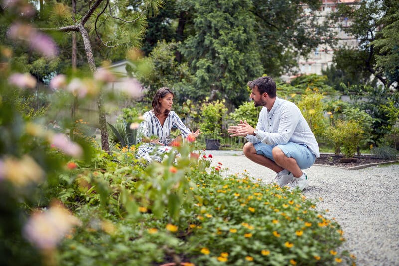 Woman and men discussing and  preparing to working exterior in garden