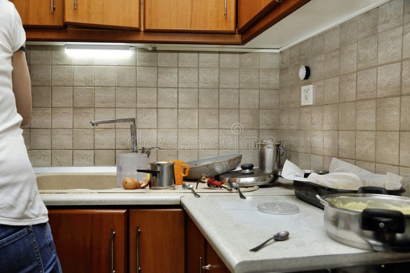 Woman in messy kitchen stock images
