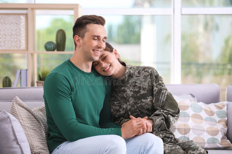Woman in military uniform with her husband on sofa stock image Woman in military uniform with her husband on sofa stock image